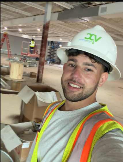Santino LaBoy in a hard hat on a construction jobsite